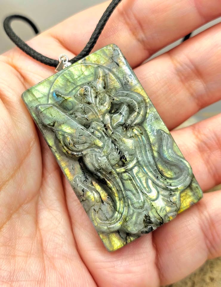 A rectangular carved pendant necklace featuring a fox warrior god figure made from nature labradorite display on hand -My Aura Gemstones