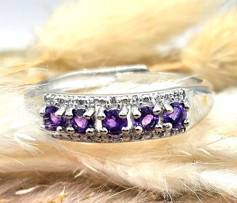 Silver adjustable ring with natural purple amethyst gemstones and clear accent stones displayed on a hand against a white background