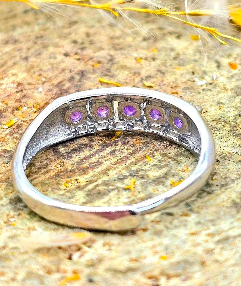 Silver adjustable ring with natural purple amethyst gemstones and clear accent stones displayed on a hand against a white background
