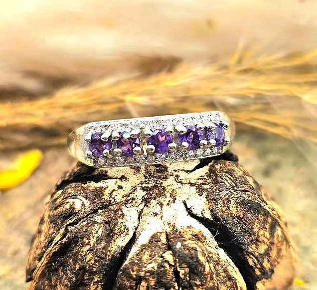 Silver adjustable ring with natural purple amethyst gemstones and clear accent stones displayed on a hand against a white background