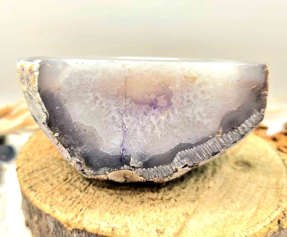 Natural druzy geode crystal with sparkling cavern displayed on white background, polished slice showing layered mineral bands-My Aura Gemstones