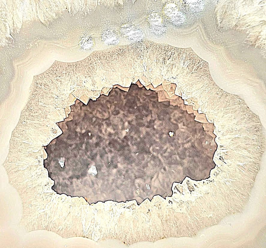 Natural druzy geode crystal with sparkling cavern displayed on white background, polished slice showing layered mineral bands-My Aura Gemstones