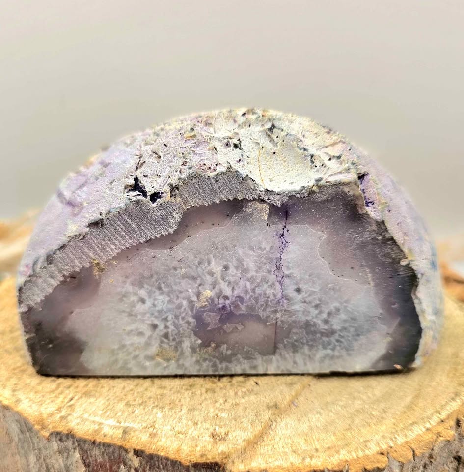 Natural druzy geode crystal with sparkling cavern displayed on white background, polished slice showing layered mineral bands-My Aura Gemstones
