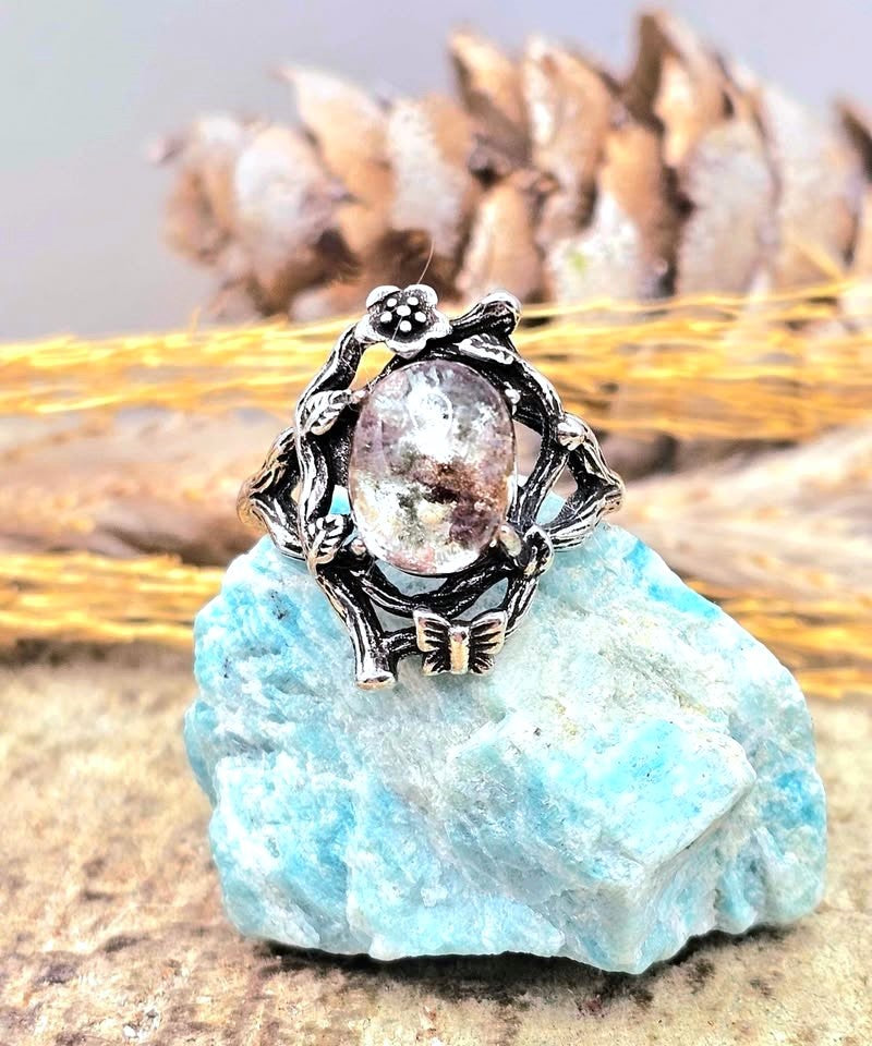 Garden quartz ring with high‑clarity crystal and green‑brown inclusions, floral wood‑branch band with butterfly, adjustable size, front view-My Aura Gemstones