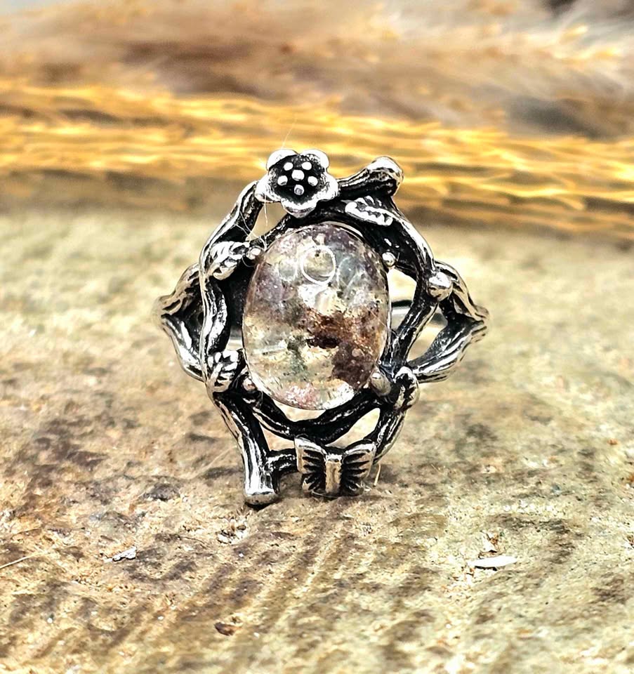 Garden quartz ring with high‑clarity crystal and green‑brown inclusions, floral wood‑branch band with butterfly, adjustable size, front view-My Aura Gemstones