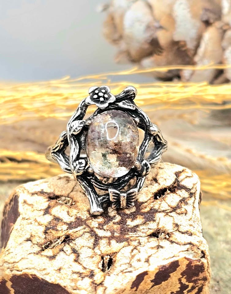 Garden quartz ring with high‑clarity crystal and green‑brown inclusions, floral wood‑branch band with butterfly, adjustable size, front view -My Aura Gemstones