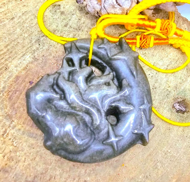 A gold obsidian stone carved  pendant featuring a nine tails fox on crescent moon in top view threaded with a bright yellow cord -My Aura Gemstones