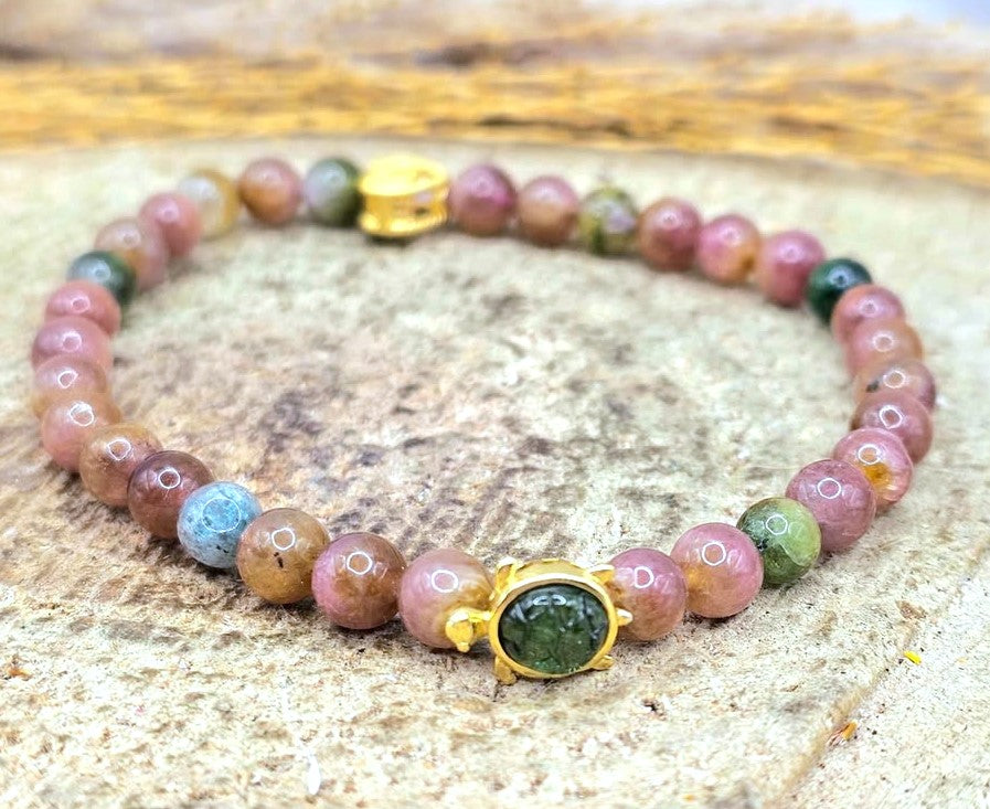 A beaded bracelet with natural mixed tourmaline beads, featuring a gold tone cute turtle charm with green tourmaline shell at closed up view -My Aura Gemstones