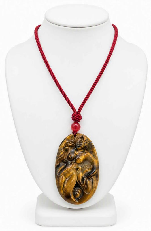 A carved oval pendant made of golden-brown tiger's eye stone carved mermaid,  pendant threaded on a red cord with a red bead display in jewelry stand-My Aura Gemstones