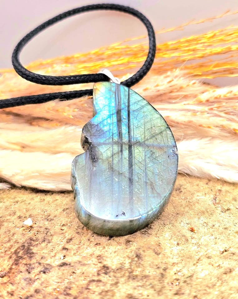 A carved labradorite  horse with a dragon pendant necklace featuring a detailed figure design with a shimmering blue-green iridescent at back side- My Aura Gemstones. 