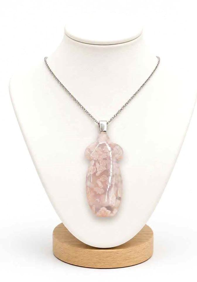 A silver chain necklace with a polished, cheongsam shaped light pink stone pendant, displayed on jewelry stand-My Aura Gemstones