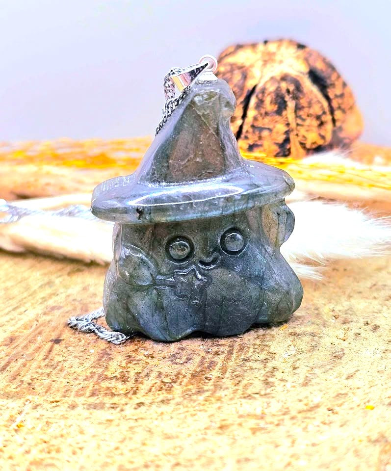 Natural labradorite carved ghost wizard-shaped pendant standing on wood slice - My Aura Gemstones.