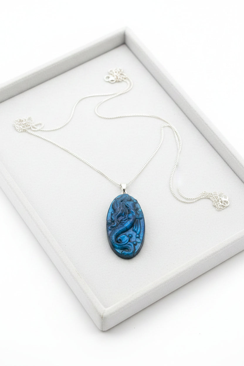 Labradorite carved pendant featuring a mermaid design, suspended from a silver chain, displayed on jewelry tray -My Aura Gemstones