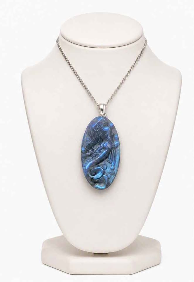 Labradorite carved pendant featuring a mermaid design, suspended from a silver chain, displayed on jewelry stand with white background-My Aura Gemstones
