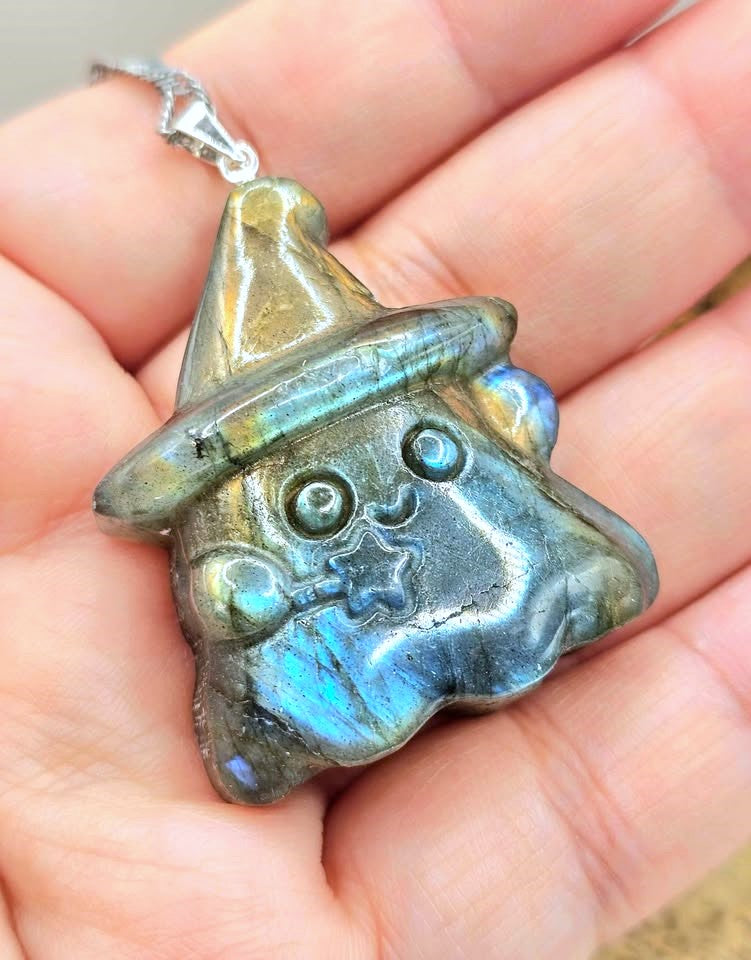 Natural labradorite carved ghost wizard-shaped pendant on hand at front view- My Aura Gemstones.