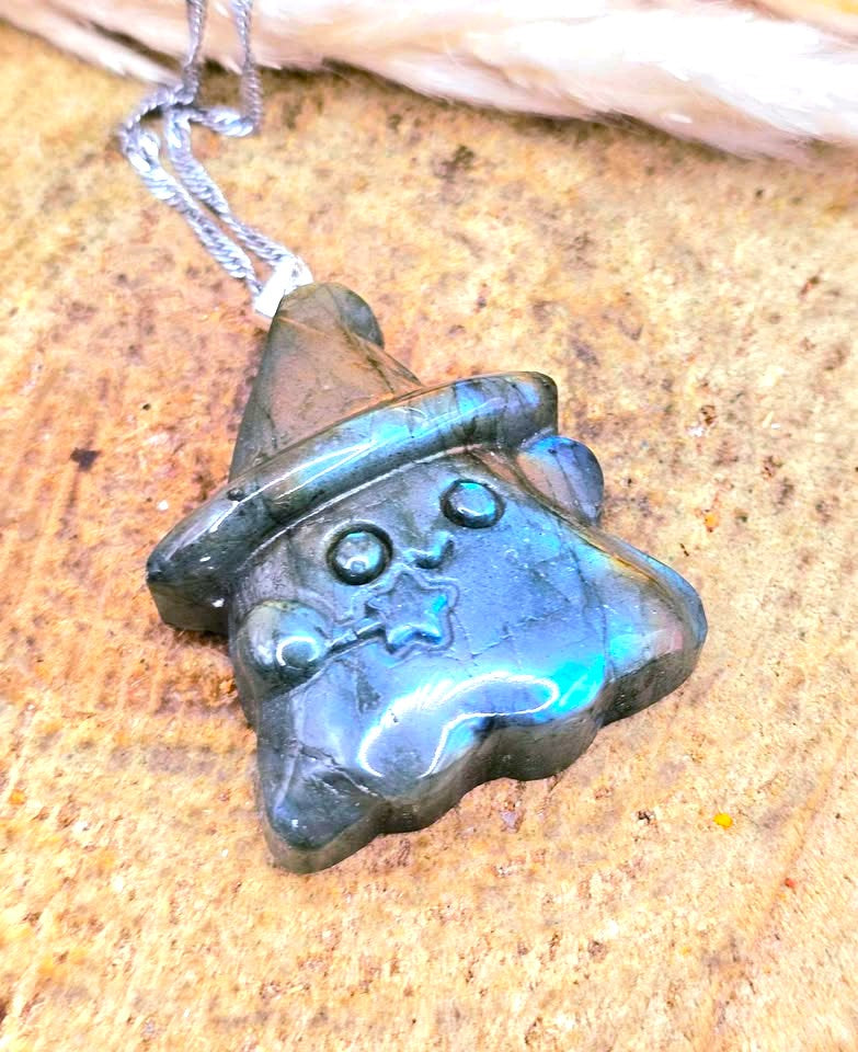 Natural labradorite carved ghost wizard-shaped pendant on wood slice at top view- My Aura Gemstones.