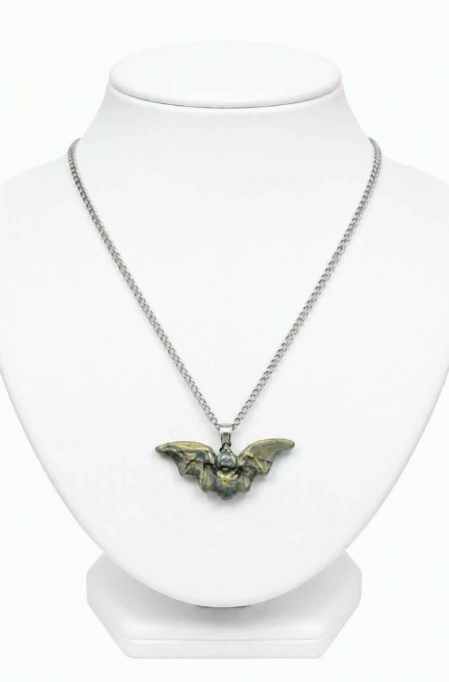 A silver chain necklace with a bat pendant, displayed on a white mannequin bust against a white background.