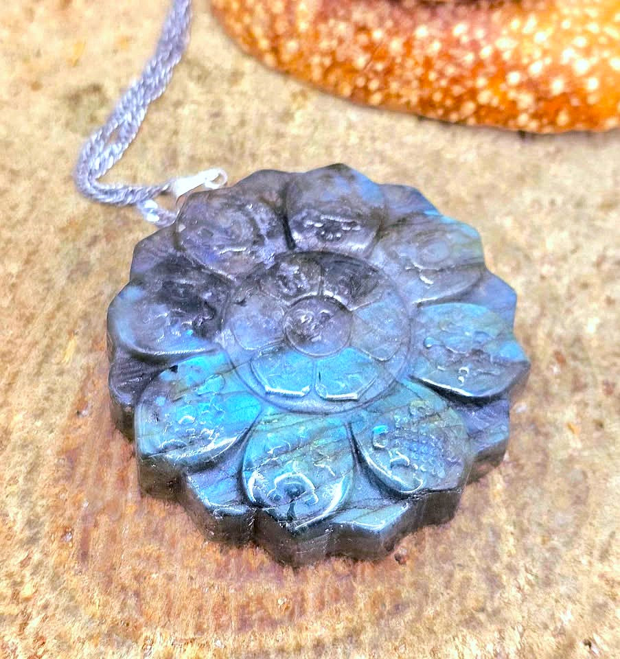Natural Labradorite Tibet Buddhism Eight Auspicious Lotus Double Carving Pendant Necklace displays on wood slice in top view