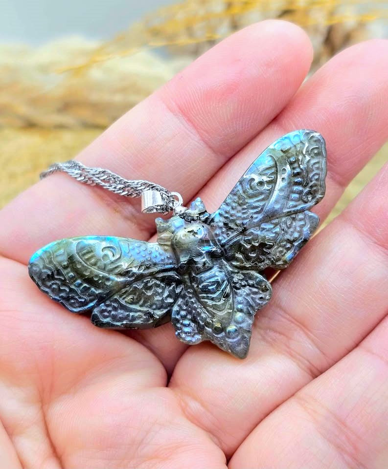Natural Labradorite Moth With Skull Pendant Necklace displays hand in front view-My Aura Gemstones