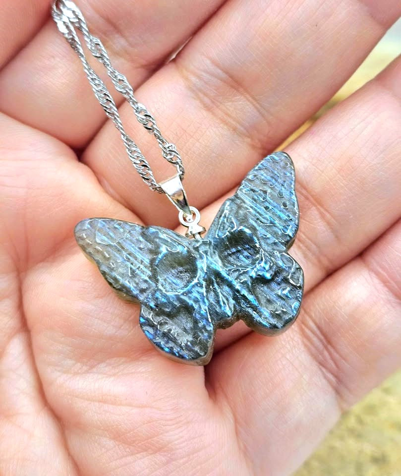 Labradorite carved hidden skull butterfly pendant necklace worn on hand — My Aura Gemstones