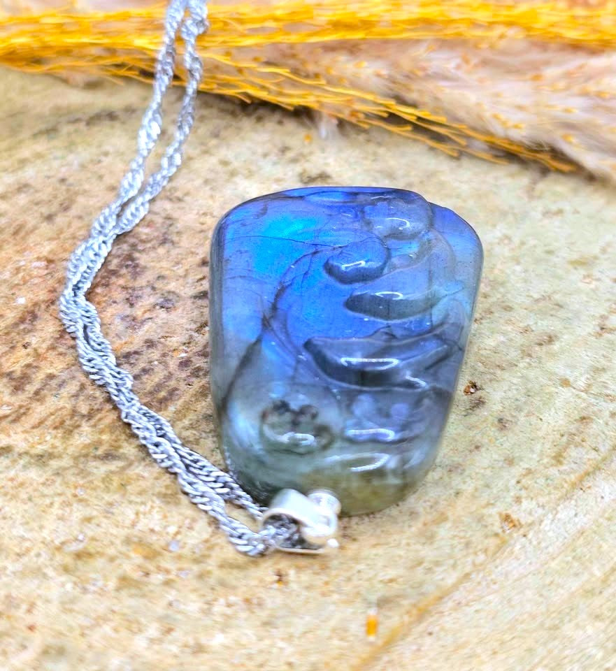 Natural labradorite dolphin pendant necklace with strong blue flash, displayed on a textured natural surface — My Aura Gemstones