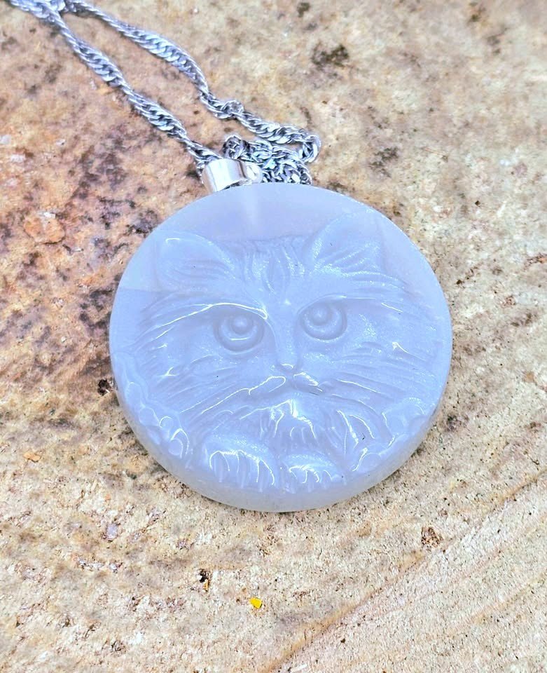 Carved round crystal cat face pendant jewelry, angled view — My Aura Gemstones