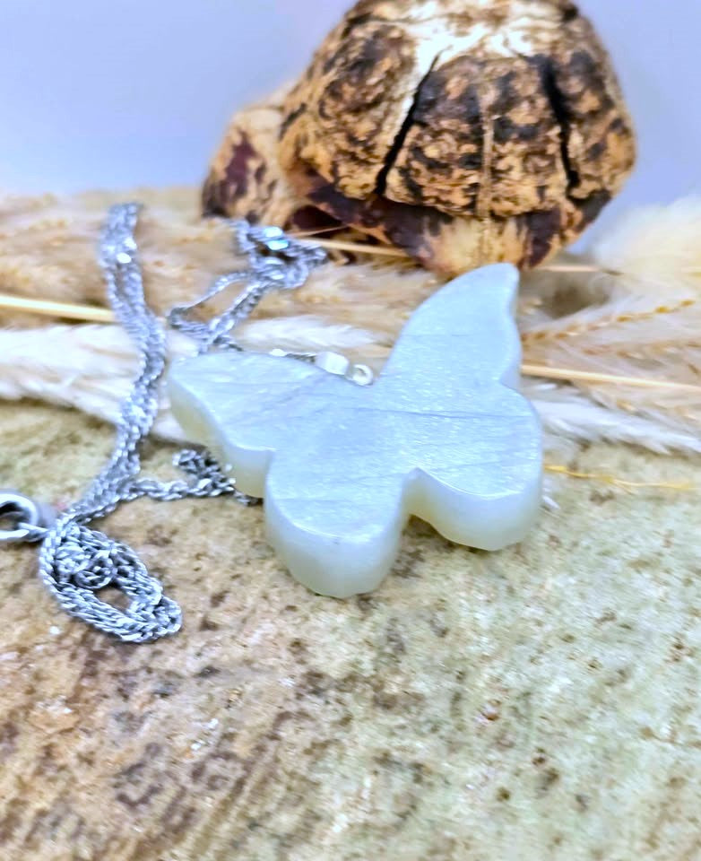 Carved butterfly crystal pendant held to show size — My Aura Gemstones
