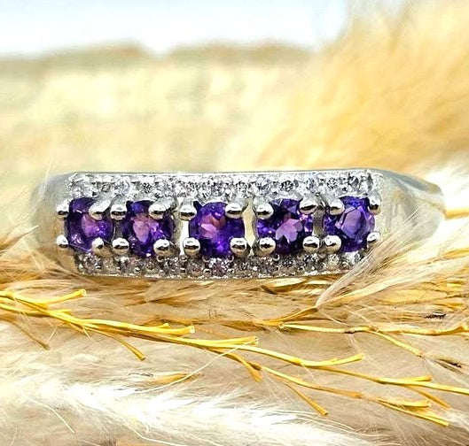 Silver adjustable ring with natural purple amethyst gemstones and clear accent stones displayed on a hand against a white background
