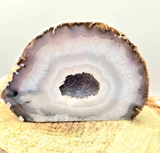 Natural druzy geode crystal with sparkling cavern displayed on white background, polished slice showing layered mineral bands-My Aura Gemstones