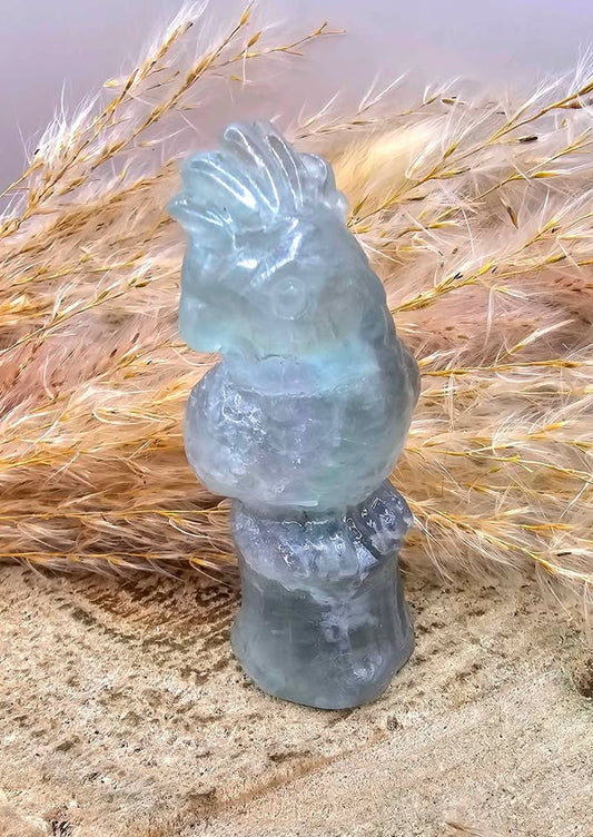 Hand-carved fluorite parrot figure on tree stump — My Aura Gemstones