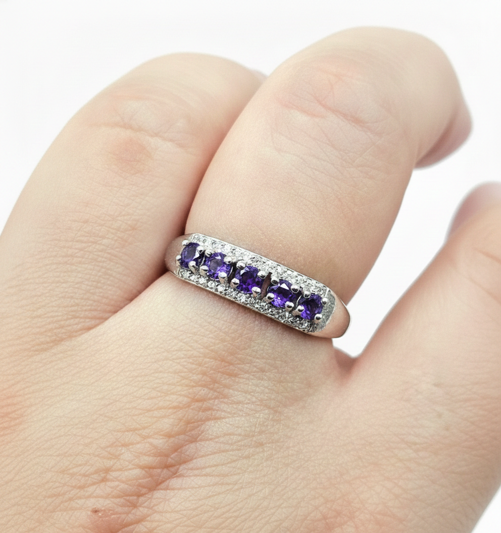 Silver adjustable ring with natural purple amethyst gemstones and clear accent stones displayed on a hand against a white background